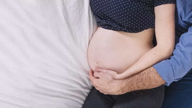 husband-and-pregnant-woman-on-bed